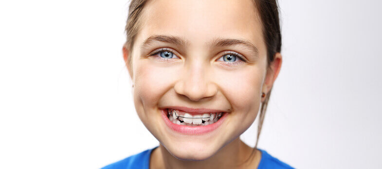 Children's braces Wimbledon - A joyful young girl with a bright smile, showcasing her new braces, represents a happy patient of Ridgway Dental, a dental clinic in Wimbledon. Her blue top contrasts nicely with her clear complexion and radiant smile, highlighting the effective and aesthetically pleasing dental braces offered by the clinic. The image perfectly encapsulates Ridgway Dental's commitment to providing specialized orthodontic care for children in Wimbledon, ensuring a comfortable and positive experience.